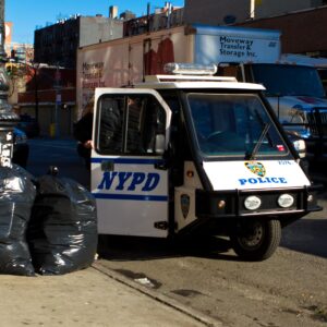 NYPD vehicle parked near garbage bags