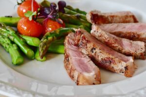 Vegetables and steak on a white plate